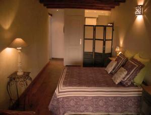 a bedroom with a bed with pillows and a lamp at La Grange aux Loirs B&B in Courtioux +6 photos