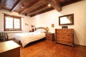 1 dormitorio con cama, tocador y espejo en Pleta Aldosa, Casa rustica con chimenea y jardin, Zona Vallnord, en La Massana