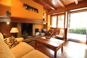 ein Wohnzimmer mit einem Sofa und einem Kamin in der Unterkunft Pleta Aldosa, Casa rustica con chimenea y jardin, Zona Vallnord in La Massana