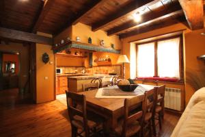 a kitchen with a wooden table with chairs and a kitchen with a stove at Pleta Aldosa, Casa rustica con chimenea y jardin, Zona Vallnord in La Massana