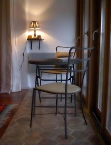 een tafel en stoelen in een kamer met een lamp bij La Grange aux Loirs B&B in Courtioux