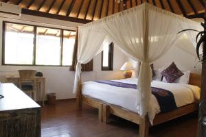 un dormitorio con una cama con dosel en Villa Margaux, en Seminyak