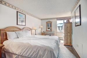 a bedroom with a large white bed and a window at Vs438 Village Square Condo in Copper Mountain