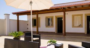 a patio with a table and an umbrella at I Ruscioli in Torre Chianca