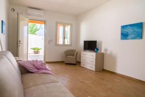 a living room with a couch and a tv at I Ruscioli in Torre Chianca