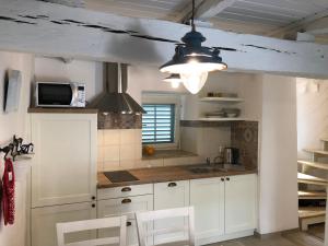a kitchen with white cabinets and a ceiling at Apartment Susanj in Mošćenice