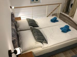 a bed with two pillows and two blue slippers at Apartment Susanj in Mošćenice