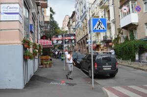 a man is standing next to a sign on a street at Hostel Golden Gates in Kyiv