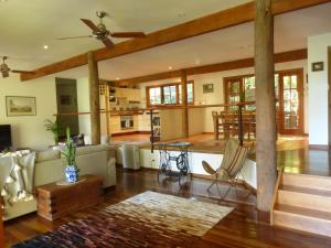 uma sala de estar com uma ventoinha de tecto e um sofá em Magnolia Cottage em Cooroy