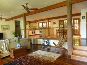 un soggiorno con ventilatore a soffitto e divano di Magnolia Cottage a Cooroy