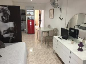 1 dormitorio con tocador blanco, TV y mesa en La Pineda De Salou Port Aventura, en La Pineda