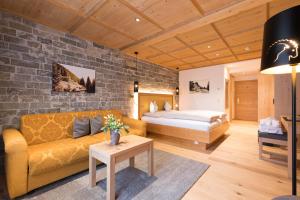 a living room with a couch and a bed at Alpenhotel Ischglerhof in Ischgl