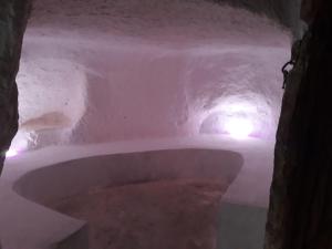 une baignoire dans une grotte avec de la neige au sol dans l'établissement Au Trait d'Union Tijma Matmata, à Matmata
