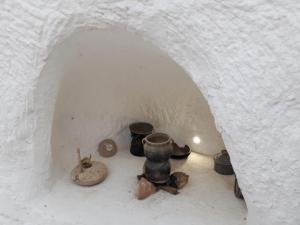 une pile de poterie assise dans une arche dans l'établissement Au Trait d'Union Tijma Matmata, à Matmata