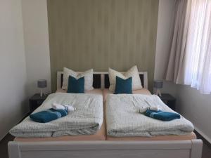 two beds with pillows on them in a bedroom at Hotel Stadt Magdeburg in Perleberg