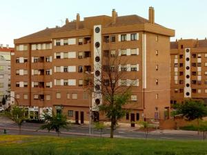 een groot bakstenen gebouw met een boom ervoor bij Estudio Bellavista in Logroño