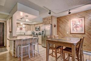 a kitchen with a table and chairs and a refrigerator at BE108 Bridge End Condo in Copper Mountain