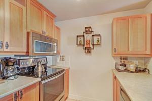 a kitchen with wooden cabinets and a stove top oven at PP301 Passage Point in Copper Mountain