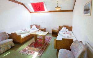 Cette chambre comprend deux lits, une table et des chaises. dans l'établissement Frühstückspension Steffi, à Sankt Kanzian