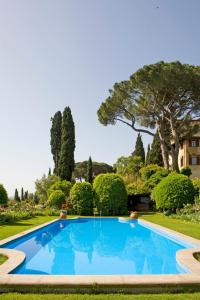a swimming pool in a garden with trees and bushes at Casa Rosa in Florence