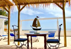 a table with chairs and a sail boat on it at Villa sunbeach in Roquebrune-sur-Argens