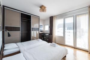 een slaapkamer met 2 bedden en een groot raam bij Samba Apartment in Wrocław