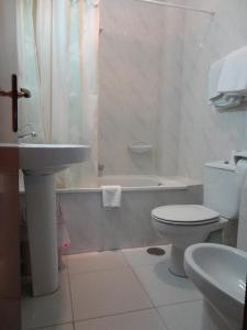 uma casa de banho com um lavatório, um WC e uma banheira em Hotel Garcas em Lavacolla