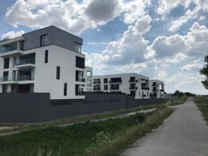 two white buildings on the side of a road at Greenbay Golf Apartments in Trenčín