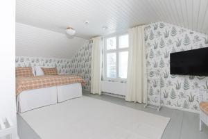 Ahlströmin Ruukki Noormarkku في بوري: غرفة نوم بسرير وتلفزيون على جدار