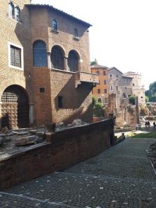 a large brick building on a cobblestone street at Portico D'ottavia in Rome