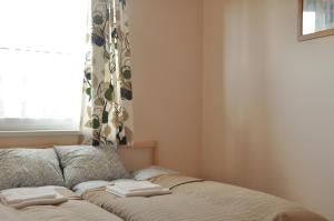 a bed with towels on it in a room with a window at Bokros Vendégház in Tordas