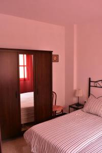 サンタ・クルス・デ・ラ・パルマにあるAtico Las Palomasのピンクの壁のベッドルーム(ベッド1台、窓付)