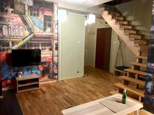 a living room with a staircase and a mural at Apartament Rolna CUBE27 in Poznań