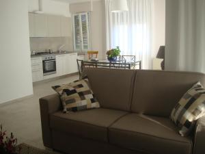 a living room with a couch and a kitchen at Serena in Cervo