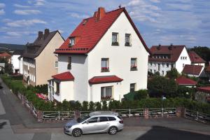 ザールフェルトにあるFerienwohnung Weidler 1の赤屋根の家の前に停めた車