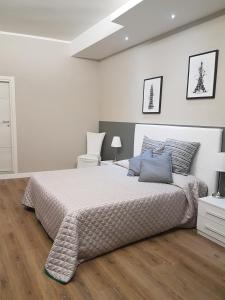 biała sypialnia z dużym łóżkiem i drewnianą podłogą w obiekcie La Baita Del Re Resort w mieście Ottaviano