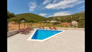a swimming pool with lounge chairs at Villa Mila Kastela in Kastel Novi
