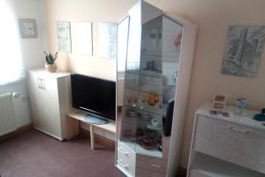 a living room with a tv and a large cabinet at Ferienwohnung Weidler 1 in Saalfeld