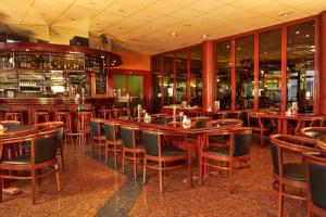 a restaurant with wooden tables and chairs and a bar at Sunday Hotel Hannover in Hannover