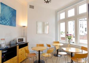 a kitchen with two tables and chairs in a room at Southsea Rocks Hotel in Portsmouth