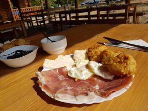 a plate of food on a table with meat and cheese at Rafting Camp Modra Rijeka in Šćepan-Polje