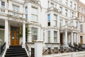 um edifício branco com uma porta amarela e escadas em St Joseph Hotel em Londres