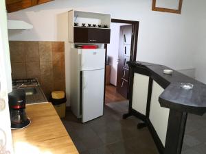 a kitchen with a white refrigerator in a room at Casa de Vacanta Aurelia in Voineasa