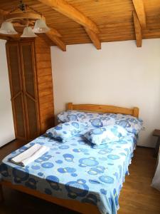 a bedroom with a bed with a blue comforter at Casa de Vacanta Aurelia in Voineasa