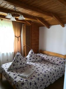 a bedroom with a bed with a book on it at Casa de Vacanta Aurelia in Voineasa