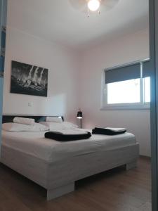 Schlafzimmer mit einem großen weißen Bett und einem Fenster in der Unterkunft Centar Guest house in Makarska