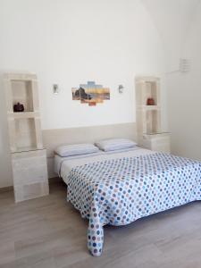 um quarto com uma cama com uma colcha azul e branca em Il Vicoletto em Casamassella