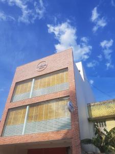 a brick building with a sign on the side of it at Micasa Hostels in Puducherry