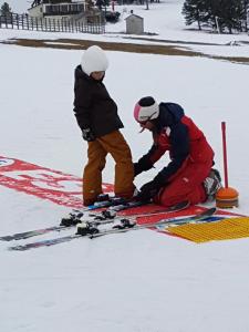two men are trying to pick up a pair of skis in the snow at Ouxis in Orlu