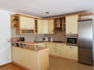 a kitchen with yellow cabinets and a stainless steel refrigerator at House Kajfes in Plitvička Jezera